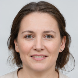 Joyful white young-adult female with medium  brown hair and grey eyes