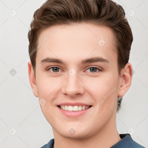 Joyful white young-adult male with short  brown hair and grey eyes