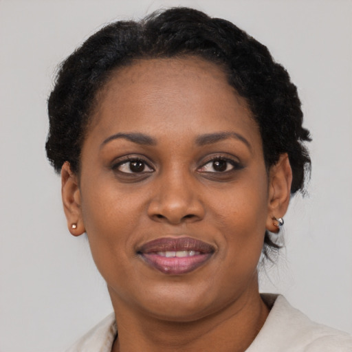 Joyful black young-adult female with short  brown hair and brown eyes