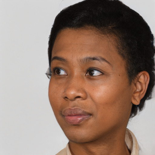 Joyful black young-adult female with short  black hair and brown eyes