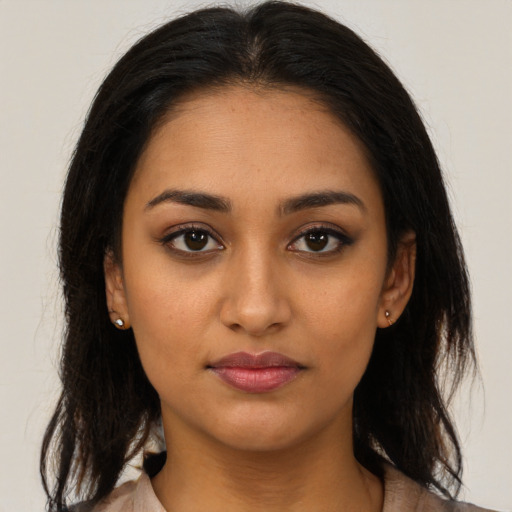 Joyful latino young-adult female with long  brown hair and brown eyes