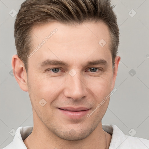 Joyful white young-adult male with short  brown hair and grey eyes