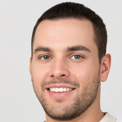 Joyful white young-adult male with short  brown hair and brown eyes