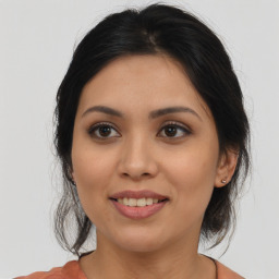 Joyful latino young-adult female with medium  brown hair and brown eyes