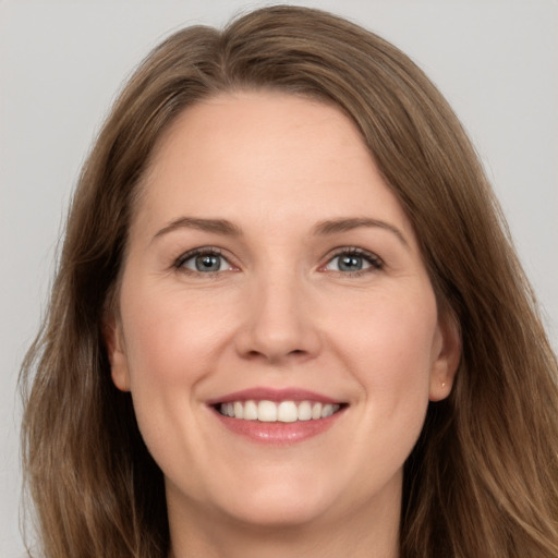 Joyful white adult female with long  brown hair and grey eyes