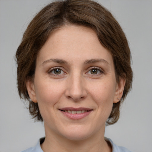 Joyful white adult female with medium  brown hair and green eyes