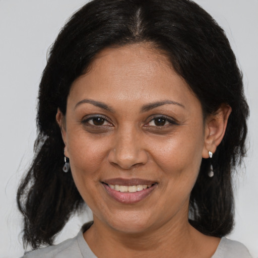 Joyful black adult female with medium  brown hair and brown eyes