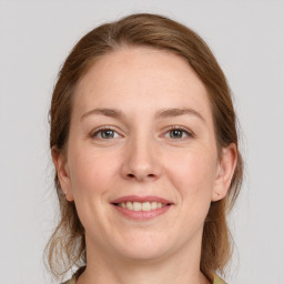 Joyful white adult female with medium  brown hair and grey eyes