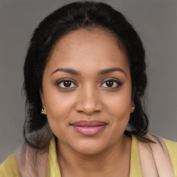 Joyful black young-adult female with long  brown hair and brown eyes