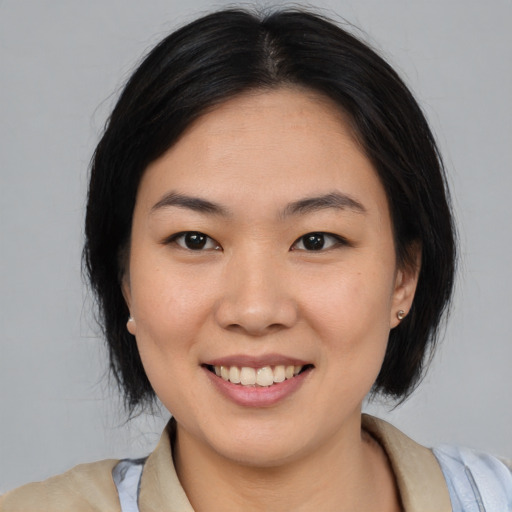 Joyful asian young-adult female with medium  black hair and brown eyes