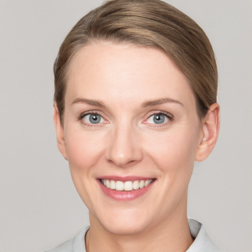 Joyful white young-adult female with short  brown hair and grey eyes