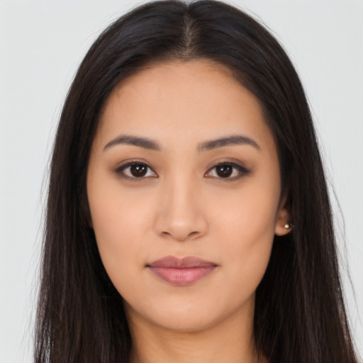 Joyful latino young-adult female with long  brown hair and brown eyes