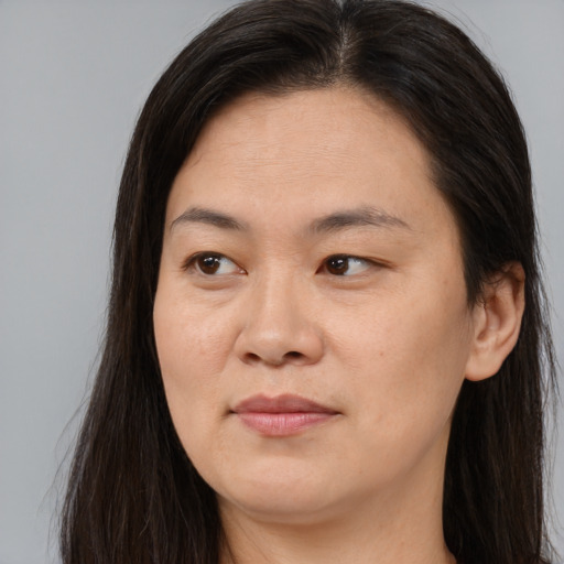 Joyful asian young-adult female with long  brown hair and brown eyes