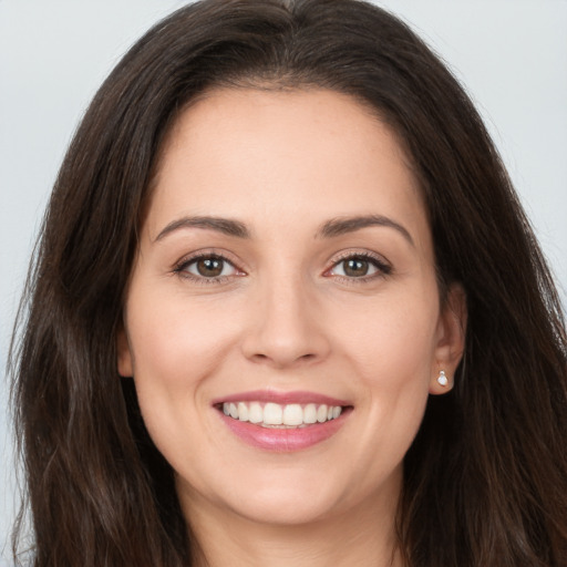 Joyful white young-adult female with long  brown hair and brown eyes