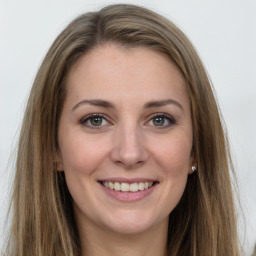 Joyful white young-adult female with long  brown hair and green eyes