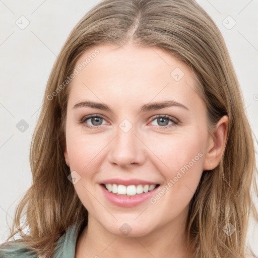 Joyful white young-adult female with long  brown hair and blue eyes