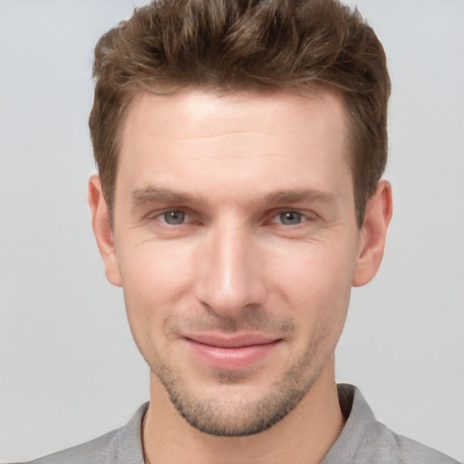 Joyful white young-adult male with short  brown hair and grey eyes