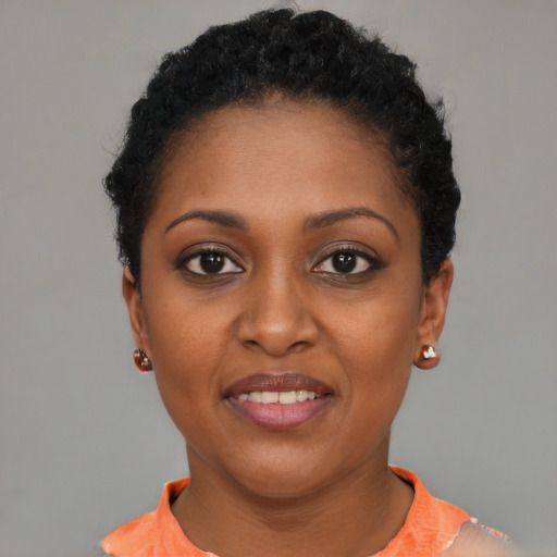 Joyful black young-adult female with short  black hair and brown eyes