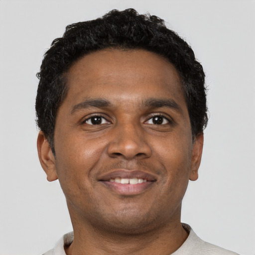 Joyful black young-adult male with short  brown hair and brown eyes