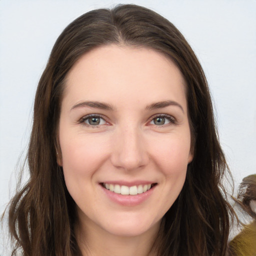 Joyful white young-adult female with long  brown hair and brown eyes