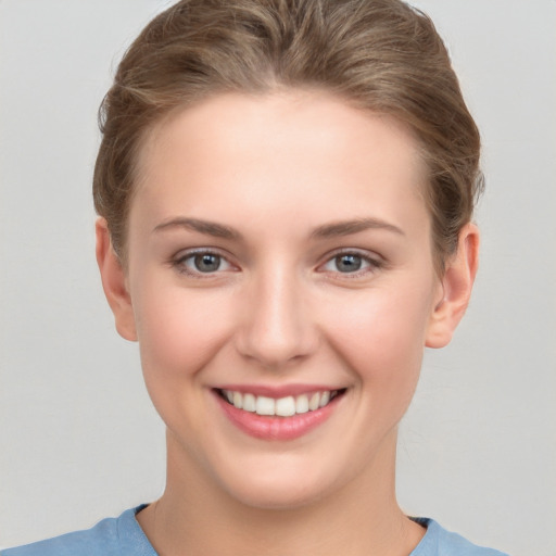 Joyful white young-adult female with short  brown hair and grey eyes