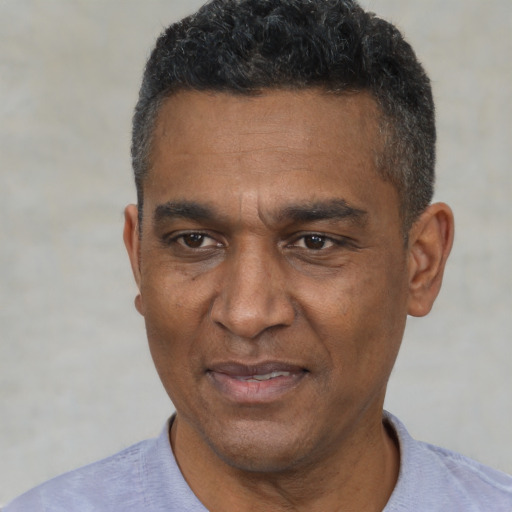 Joyful black adult male with short  black hair and brown eyes