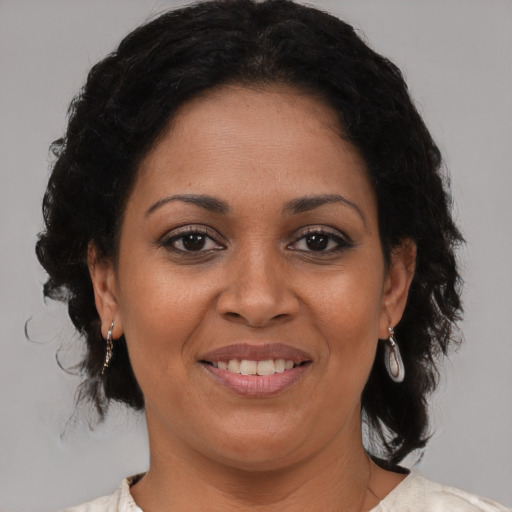 Joyful black adult female with medium  brown hair and brown eyes