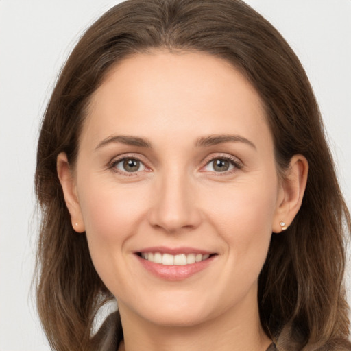 Joyful white young-adult female with long  brown hair and brown eyes