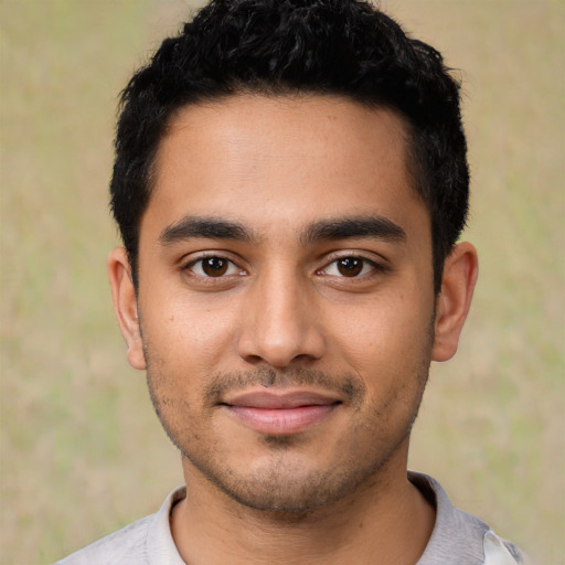 Joyful latino young-adult male with short  black hair and brown eyes