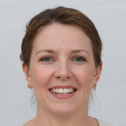 Joyful white young-adult female with short  brown hair and grey eyes