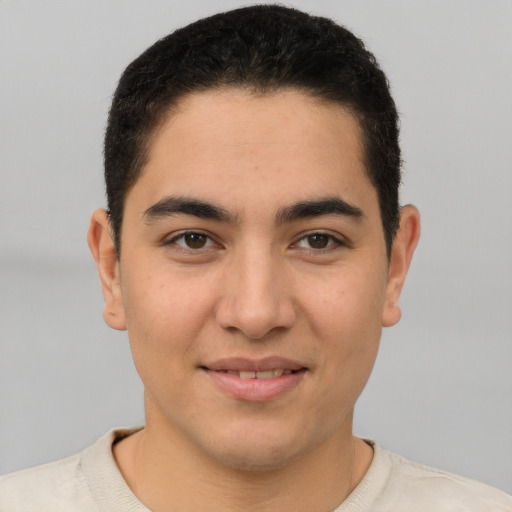 Joyful latino young-adult male with short  brown hair and brown eyes