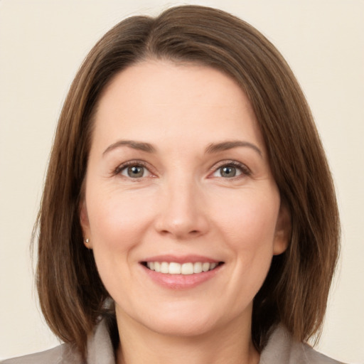 Joyful white young-adult female with medium  brown hair and green eyes