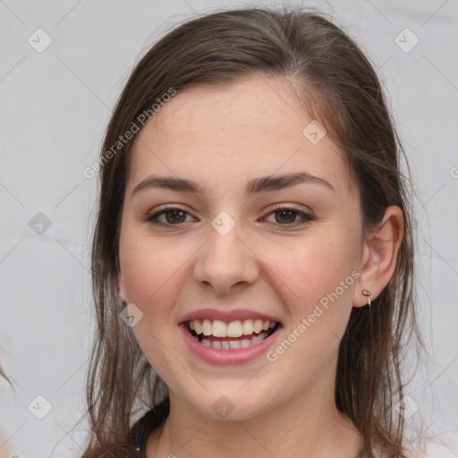 Joyful white young-adult female with long  brown hair and brown eyes