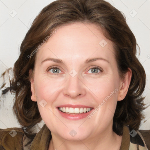 Joyful white adult female with medium  brown hair and blue eyes