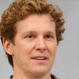 Joyful white adult male with short  brown hair and blue eyes