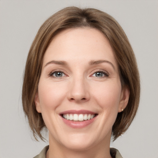 Joyful white young-adult female with medium  brown hair and grey eyes