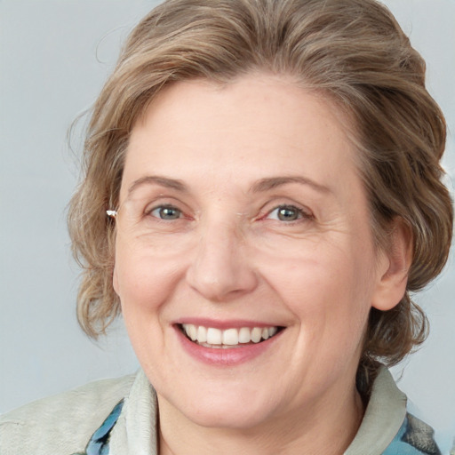 Joyful white adult female with medium  brown hair and blue eyes