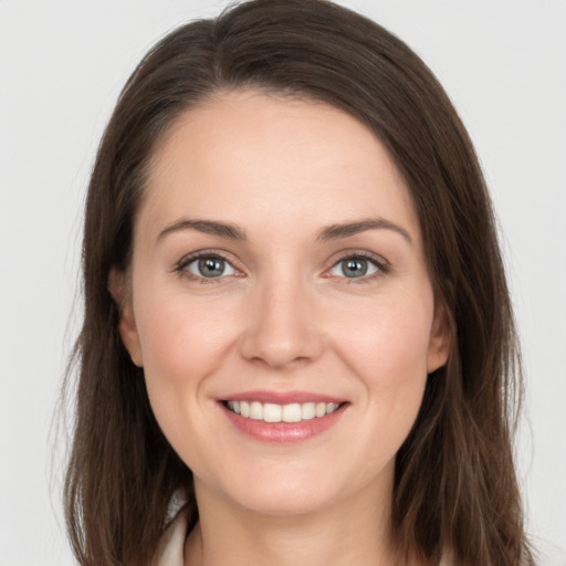 Joyful white young-adult female with long  brown hair and grey eyes