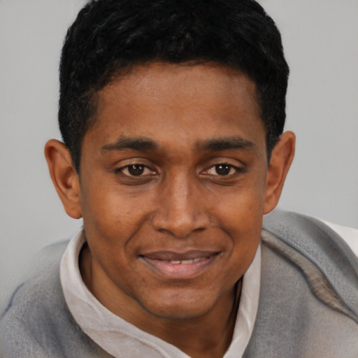 Joyful black young-adult male with short  black hair and brown eyes