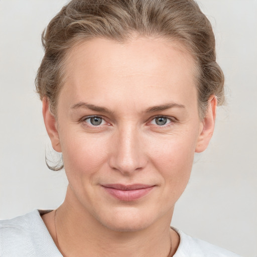 Joyful white young-adult female with short  brown hair and blue eyes