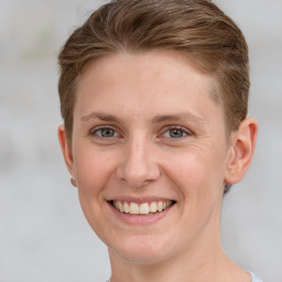 Joyful white young-adult female with short  brown hair and grey eyes