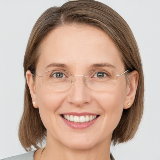 Joyful white adult female with medium  brown hair and grey eyes