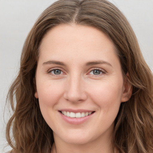 Joyful white young-adult female with long  brown hair and grey eyes