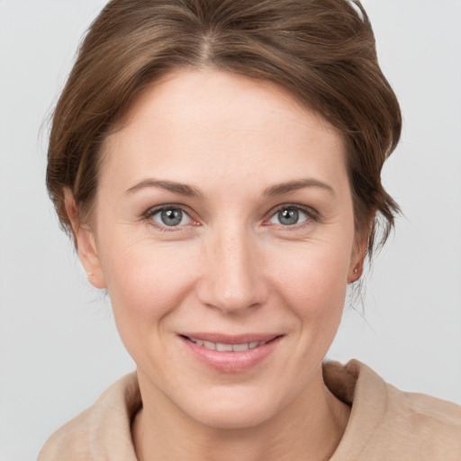 Joyful white young-adult female with short  brown hair and grey eyes