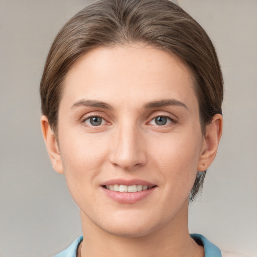 Joyful white young-adult female with short  brown hair and grey eyes