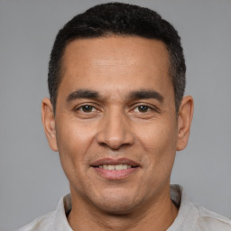 Joyful latino adult male with short  black hair and brown eyes
