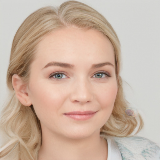 Joyful white young-adult female with long  blond hair and blue eyes