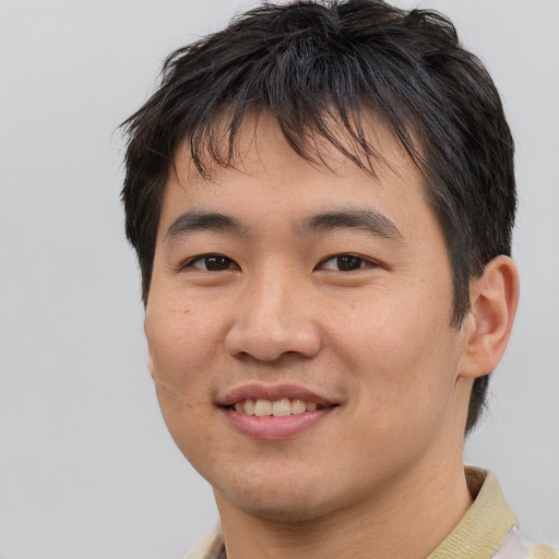 Joyful asian young-adult male with short  brown hair and brown eyes