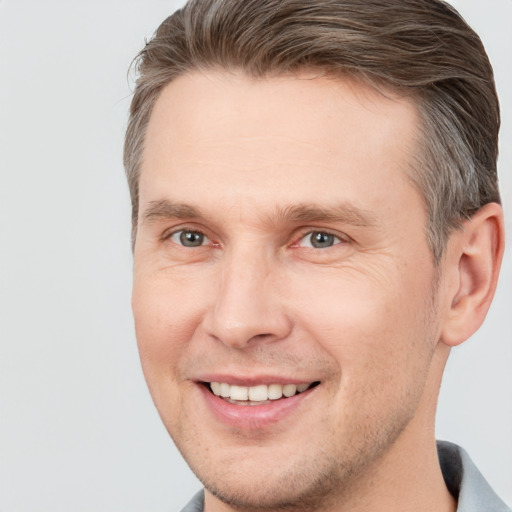 Joyful white adult male with short  brown hair and brown eyes