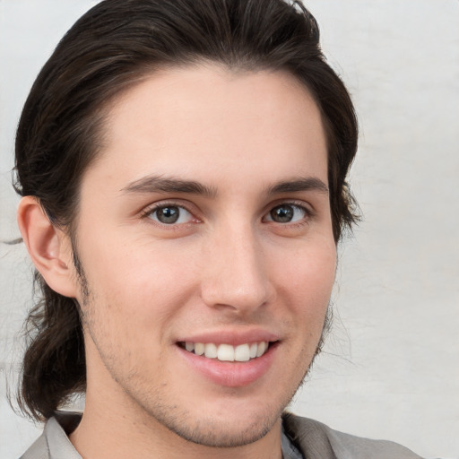 Joyful white young-adult male with medium  brown hair and brown eyes